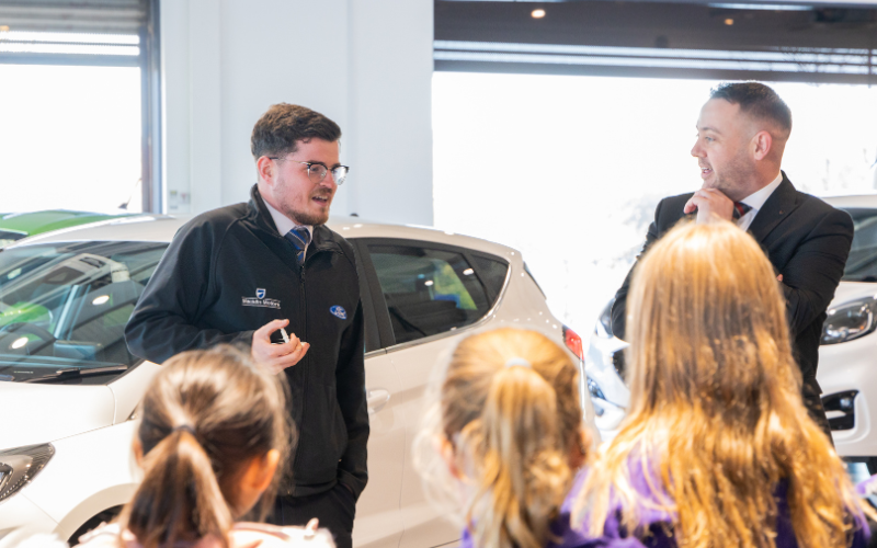 Sam Bannister Senior Sales Executive and Mark Super General Manager talking to the children